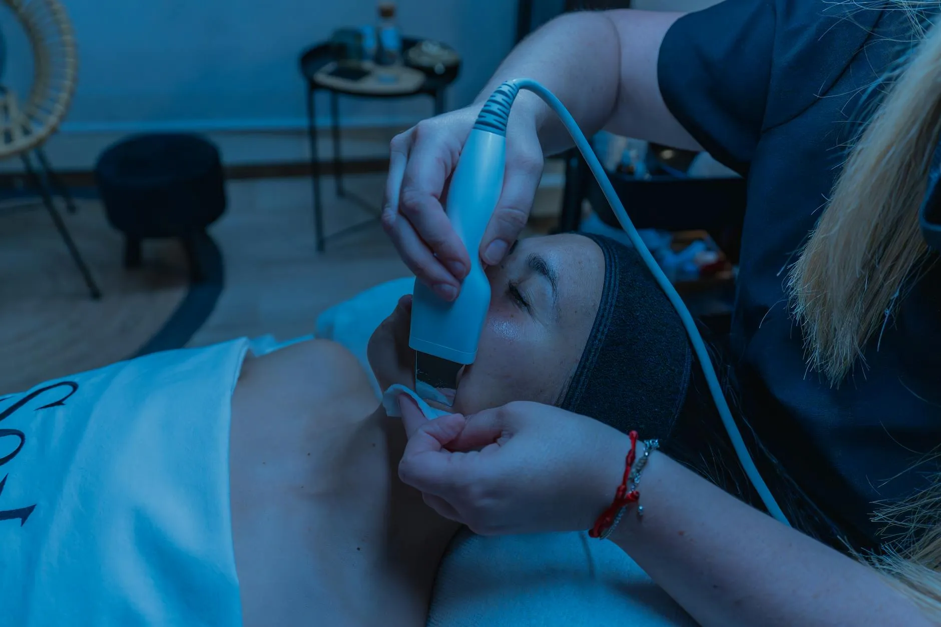 Detailní záběr na diagnostiku pleti prováděnou profesionální kosmetičkou v salonu.