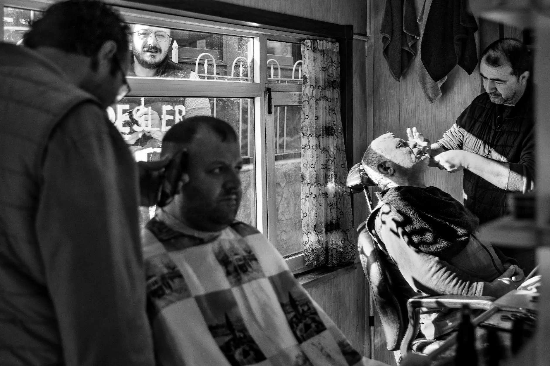 Majitelka salonu analyzuje prodejní výsledky a KPI na tabletu v moderním interiéru kadeřnictví.