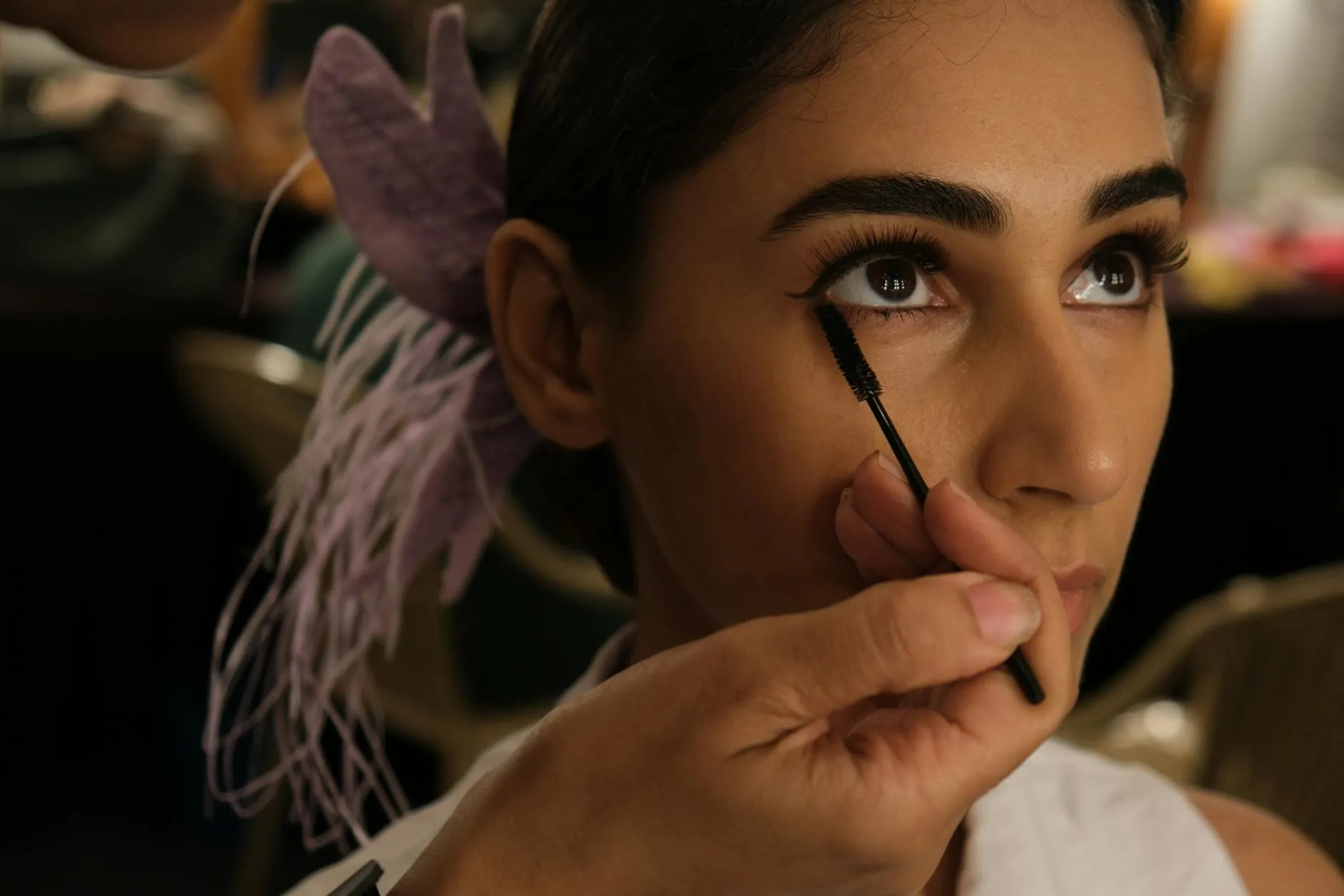 Majitelka salonu kontroluje kvalitu vlasových pramenů pro prodlužování v profesionálním prostředí