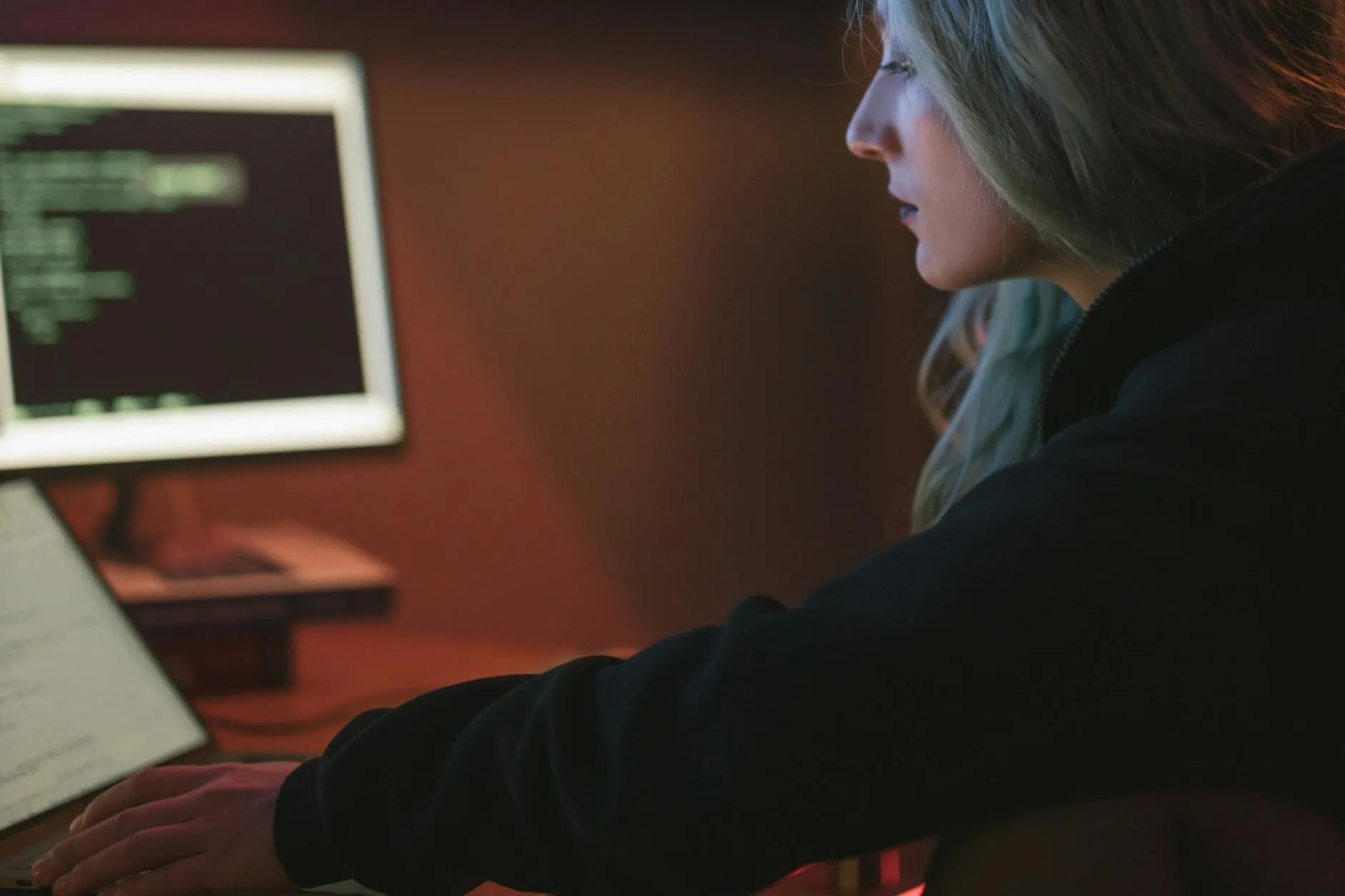 Majitelka salonu analyzuje digitální data o klientech na tabletu v moderním interiéru kadeřnictví.