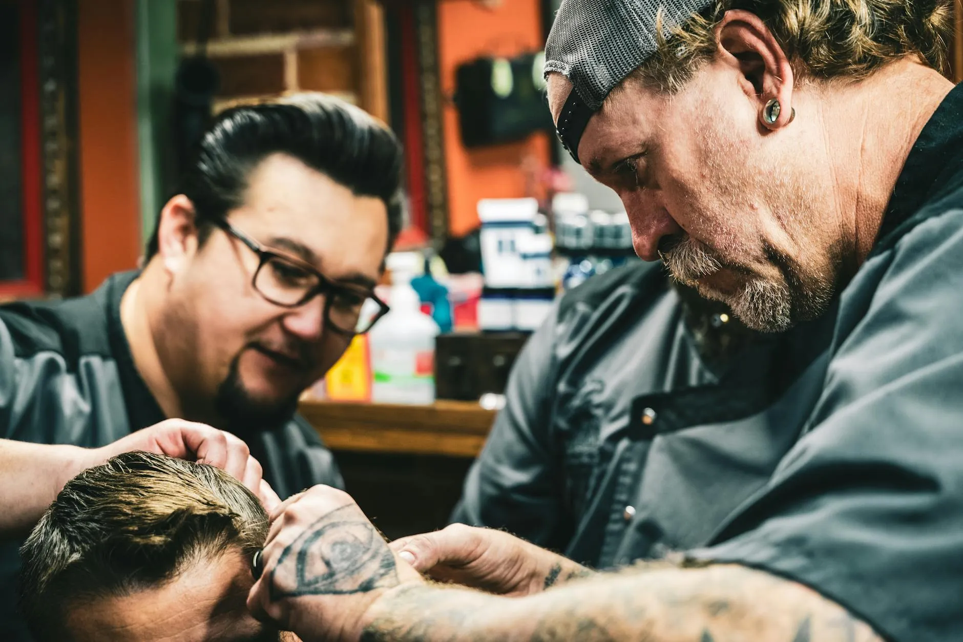 Detailní záběr na práci barbera s břitvou při tvorbě vlasového designu v moderním salonu